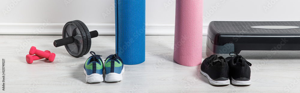 panoramic shot of yoga mats, sneakers, step platform and sport equipment on floor at home - obrazy, fototapety, plakaty 