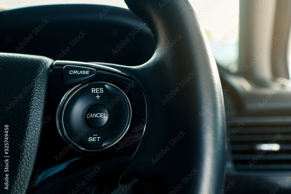 cruise control or speed control system on steering wheel in modern car, shallow depth of field