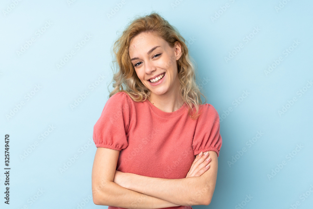 Young blonde woman isolated on blue background laughing Young blonde woman isolated on blue background laughing