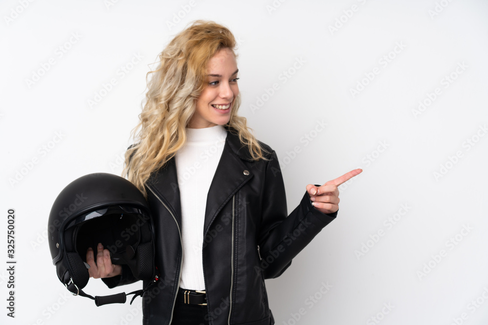 Young blonde woman with a motorcycle helmet isolated on white background pointing to the side to present a product Young blonde woman with a motorcycle helmet isolated on white background pointing to the side to present a product