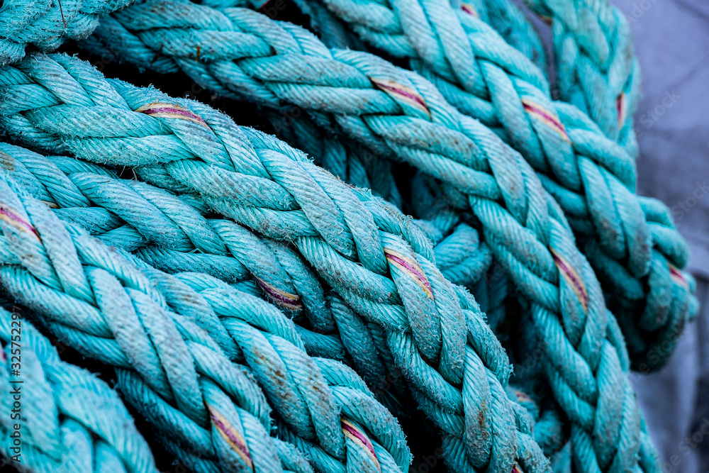 Close up sur une grosse corde tressée sur le quai d'un port, matériel de pêche