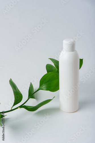 green leaves with tubes on a white background, beauty care