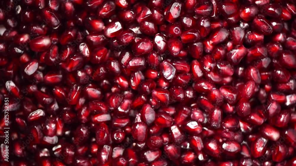 Fresh pomegranate seeds on rotating background. Top view. Green Raw organic vegetables. Vegan diet and vegetarian food concept. Fresh pomegranate seeds on rotating background. Top view. Green Raw organic vegetables. Vegan diet and vegetarian food concept.
