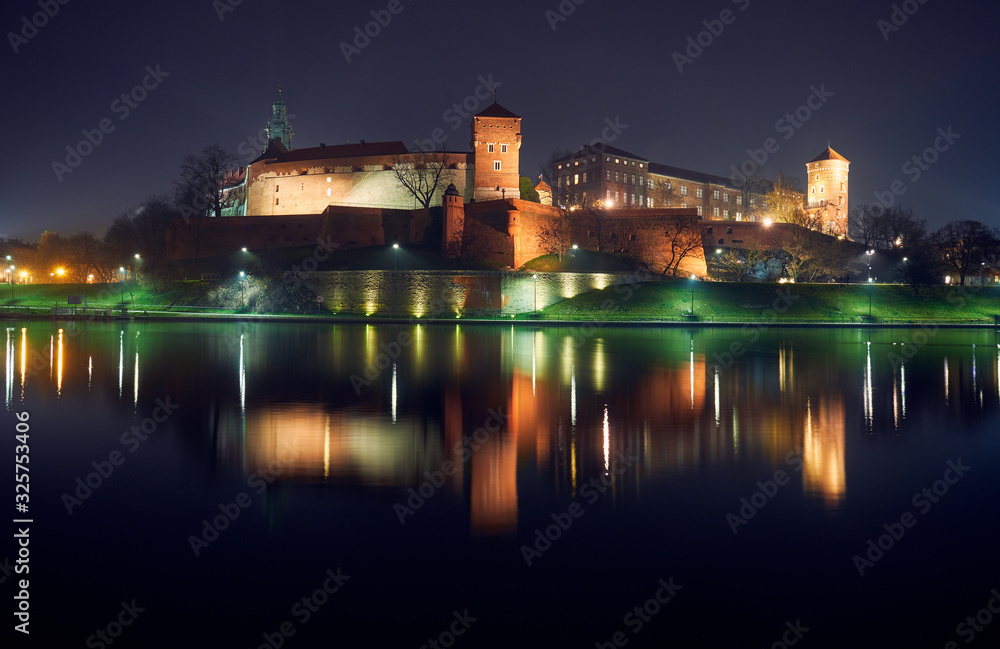 Wawel Castle by the river at night in Krakow.