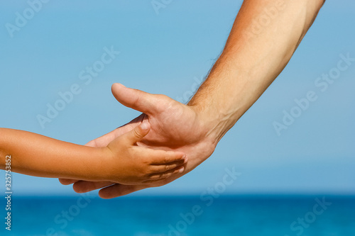 happy dad holds the hand of a child by the greek sea in nature © Kostia