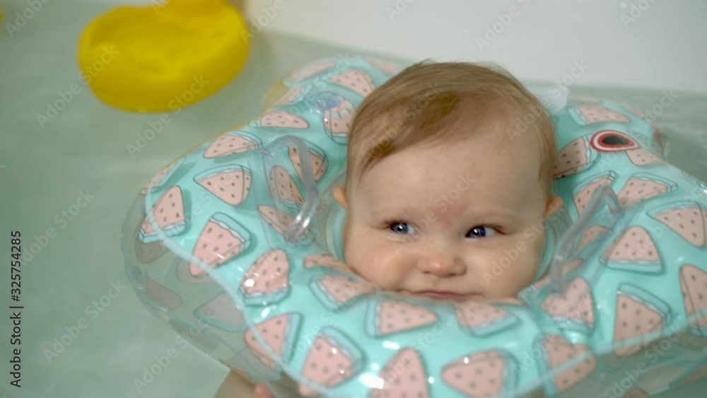 Little baby swim in the bath with an inflatable circle around his neck Little baby swim in the bath with an inflatable circle around his neck