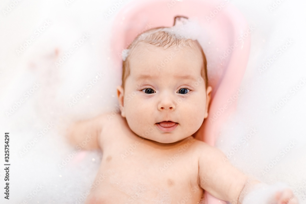 a cute little Caucasian baby is bathing in a bubble bath in the bathroom. a cute little Caucasian baby is bathing in a bubble bath in the bathroom.
