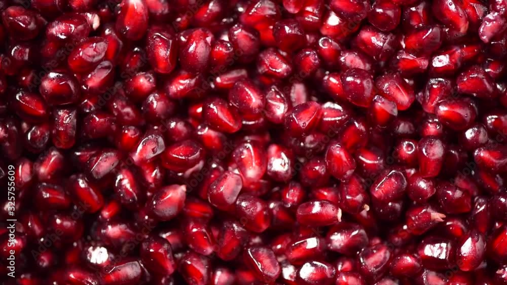 Fresh pomegranate seeds on rotating background. Top view. Green Raw organic vegetables. Vegan diet and vegetarian food concept. Fresh pomegranate seeds on rotating background. Top view. Green Raw organic vegetables. Vegan diet and vegetarian food concept.
