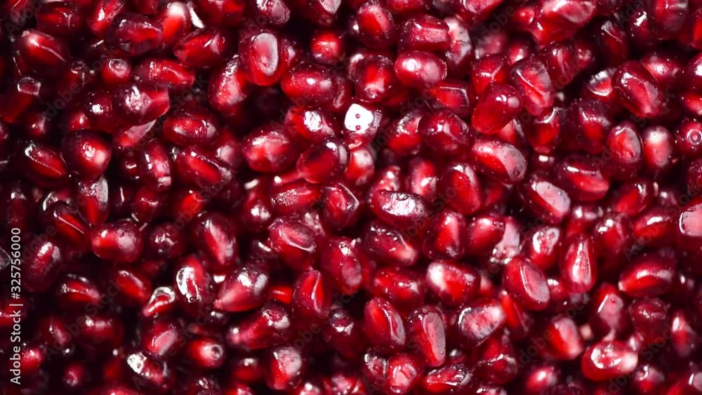 Fresh pomegranate seeds on rotating background. Top view. Green Raw organic vegetables. Vegan diet and vegetarian food concept. Fresh pomegranate seeds on rotating background. Top view. Green Raw organic vegetables. Vegan diet and vegetarian food concept.