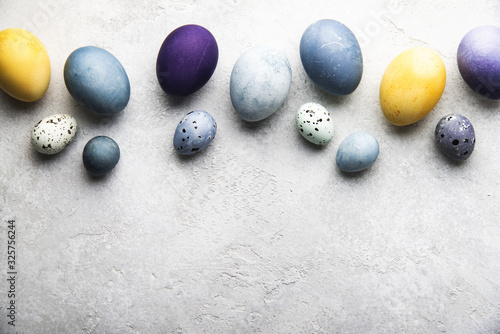 Naturally dyed colorful Easter eggs on grey concrete background 