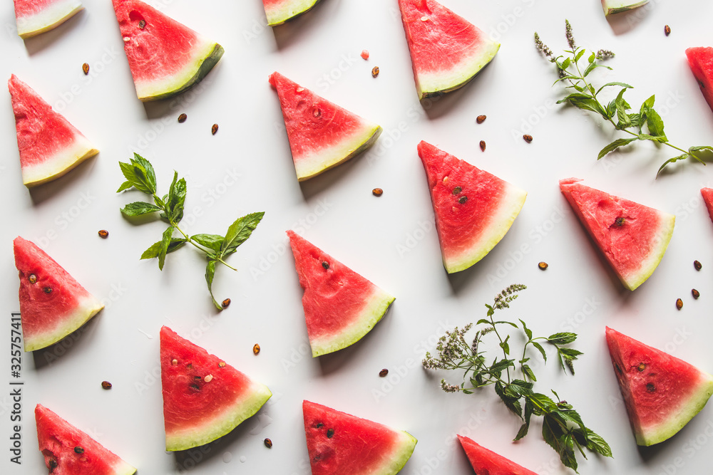 sliced triangular slices of ripe red watermelon with seeds with green mint leaves, lime sliced triangular slices of ripe red watermelon with seeds with green mint leaves, lime