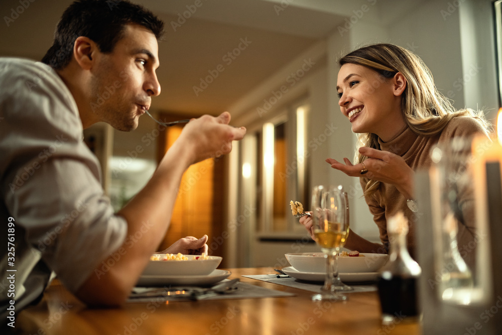 Below view of happy couple communicating during a meal at dining table. Below view of happy couple communicating during a meal at dining table.