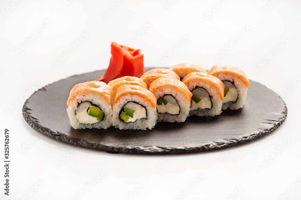 Sushi roll Philadelphia on a black round stone. Sushi roll Philadelphia on a black round stone.
