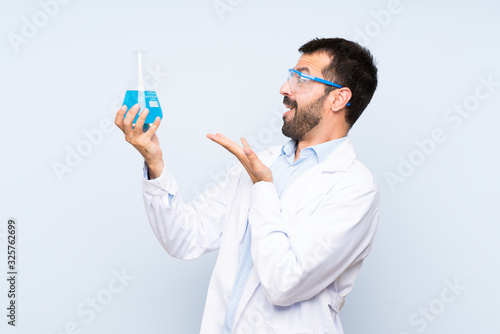 Young scientific holding laboratory flask over isolated background