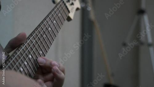 Close up of finger moving as playing guitar in slow motion mode.