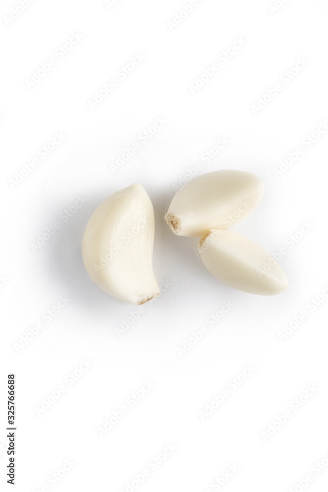 Fototapeta premium three small peeled garlic cloves isolated on white. garlic is used as effective remedy or for health prophylaxis