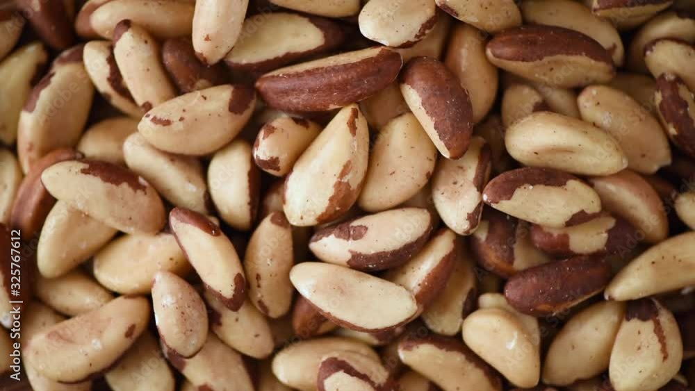Organic bazil nut texture on rotating background. Food ingredient background. Vegan, vegetarian diet. Healthy lifestyle. Natural dry fruits and nuts concept Organic bazil nut texture on rotating background. Food ingredient background. Vegan, vegetarian diet. Healthy lifestyle. Natural dry fruits and nuts concept