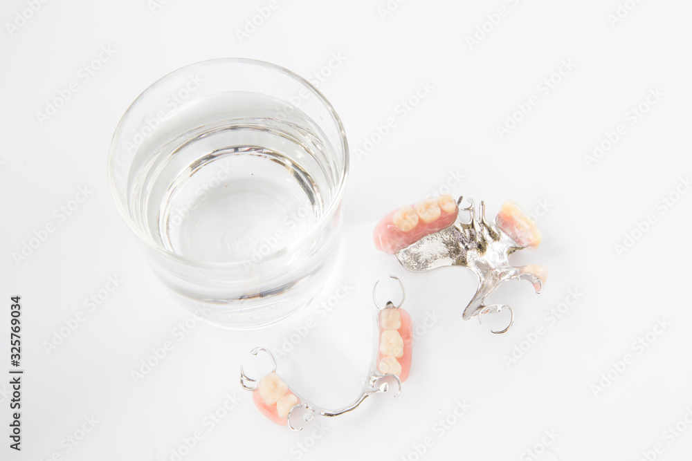 denture is cleaned in a glass of water. proper hygiene. denture is cleaned in a glass of water. proper hygiene.