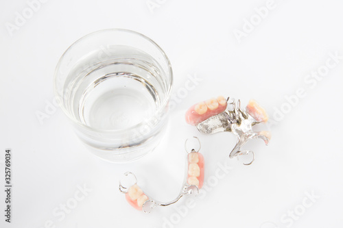 denture is cleaned in a glass of water. proper hygiene.