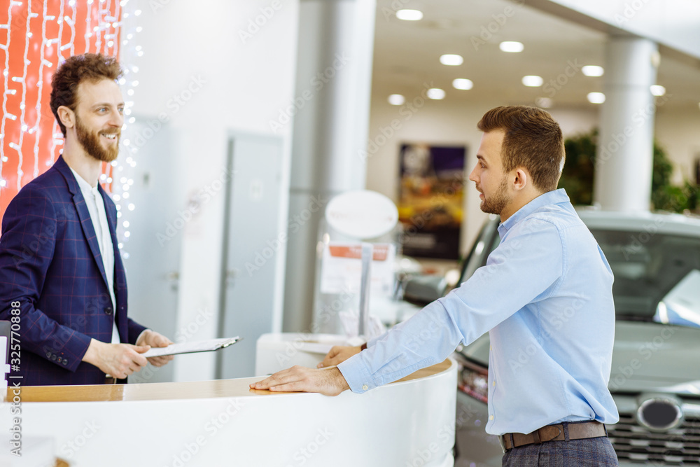side view on nice consultant welcoming buyer of car in dealership, they have nice talk, consultant ready to help with choice of car side view on nice consultant welcoming buyer of car in dealership, they have nice talk, consultant ready to help with choice of car