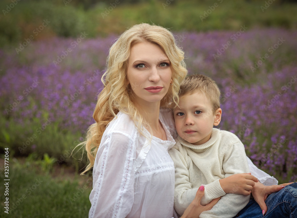 happy mom with a boy have a rest in a lavender field in summer happy mom with a boy have a rest in a lavender field in summer