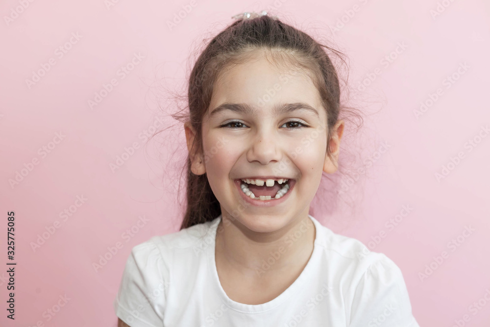 Portrait of happy laughing child girl on pink background. Smiling kid. Positive emotions. Portrait of happy laughing child girl on pink background. Smiling kid. Positive emotions.