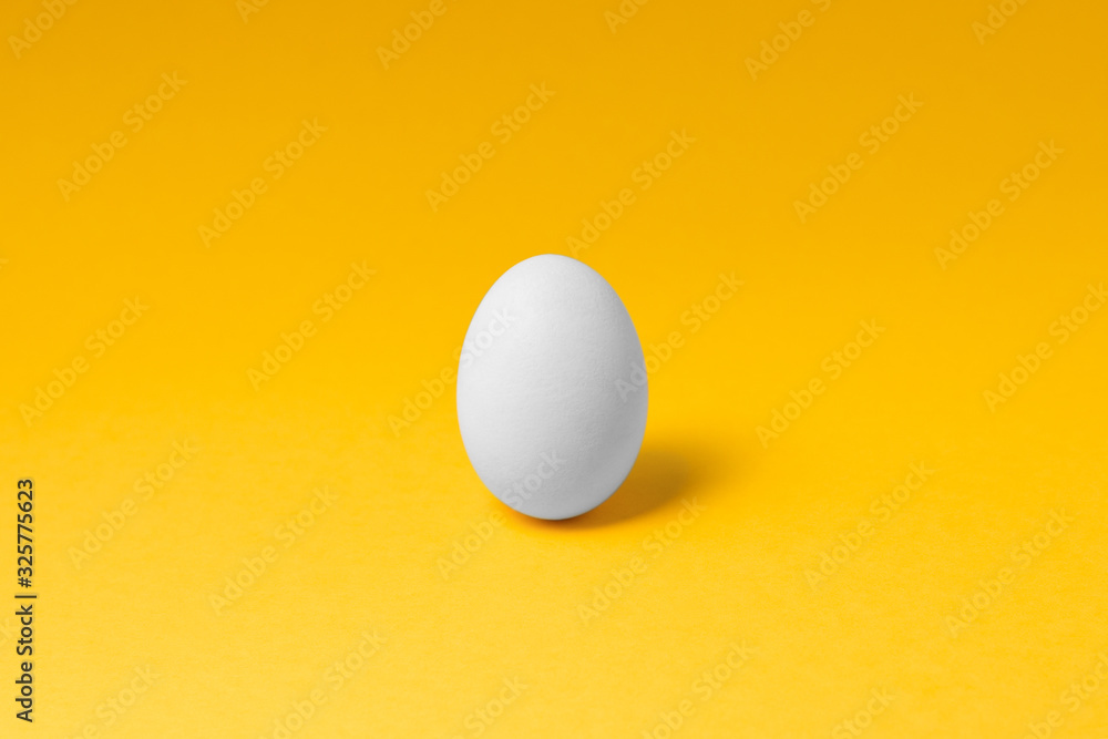 one white egg in center on yellow background. easter concept design one white egg in center on yellow background. easter concept design