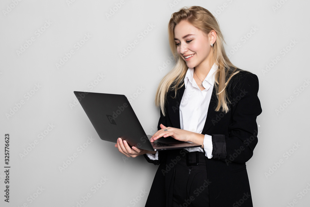Successful business woman with laptop is standing on isolated white background. Successful business woman with laptop is standing on isolated white background.