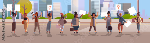 mix race activists holding placards with female gender sign feminist demonstration girl power movement rights protection women empowerment concept cityscape background horizontal full length vector