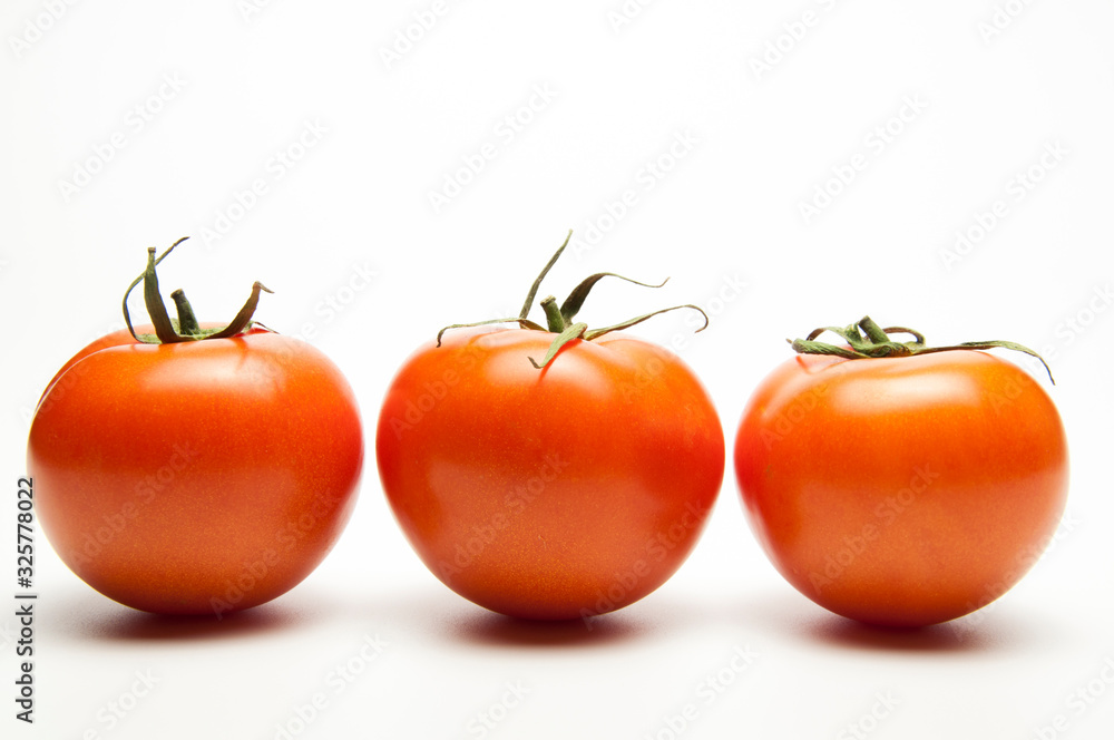 Fresh tomatoes. Red with a green spine. Vegetarian food. On white background Fresh tomatoes. Red with a green spine. Vegetarian food. On white background