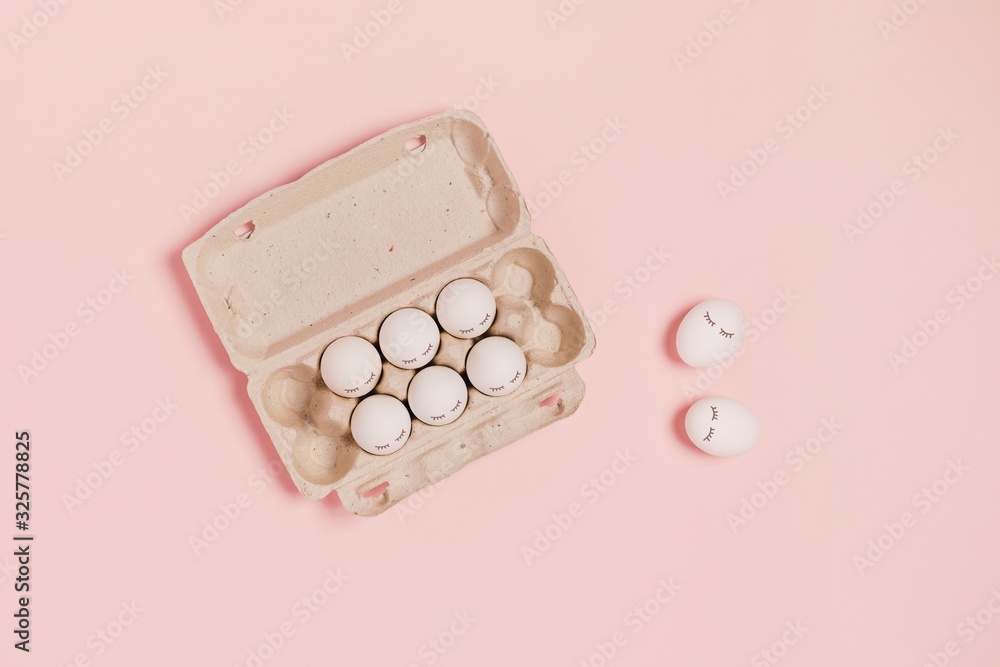 Happy Easter. White eggs with eyes in paper packaging on pink background. Flat lay, top view, copy space. Happy Easter. White eggs with eyes in paper packaging on pink background. Flat lay, top view, copy space.