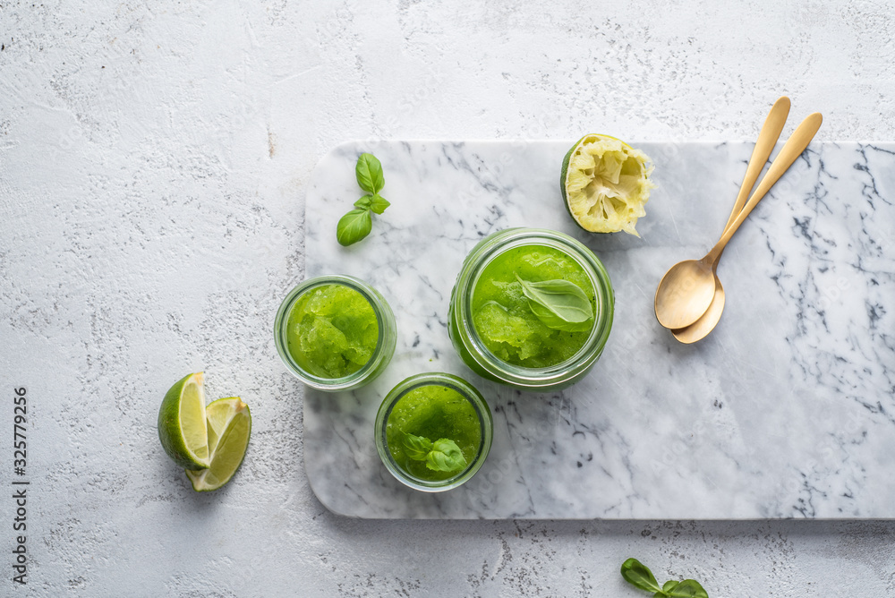 Lime, mint and basil green slushy on white background. Copy space. Text space. Lime, mint and basil green slushy on white background. Copy space. Text space.
