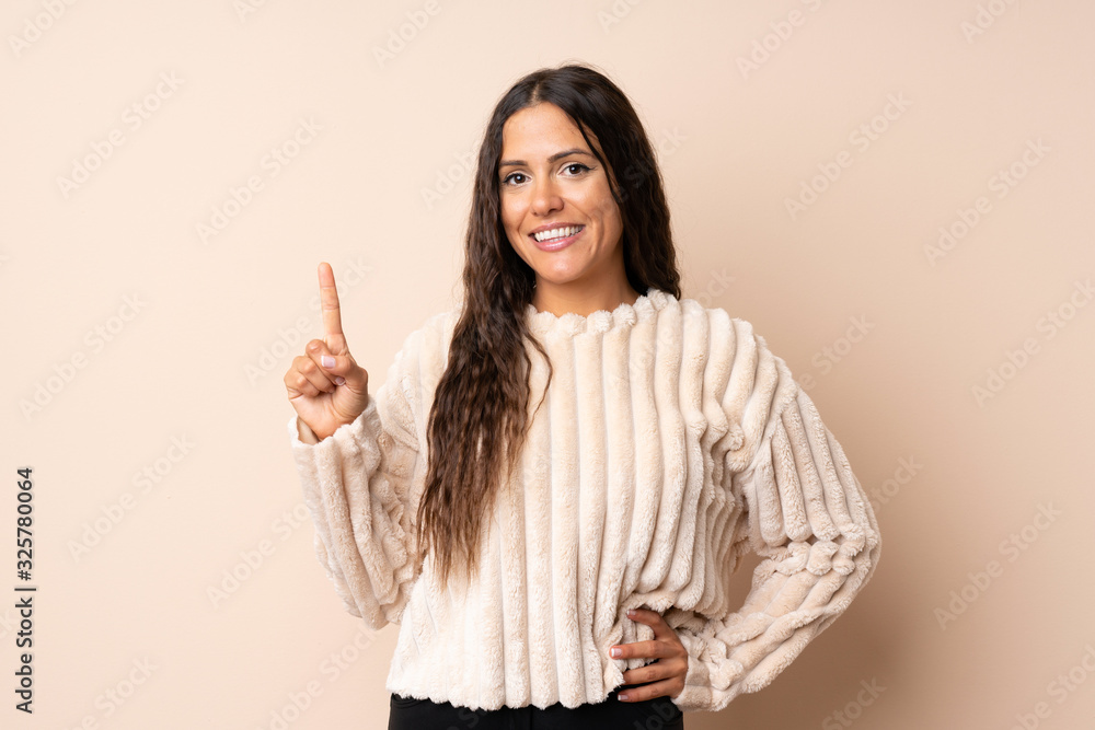 Young woman over isolated background showing and lifting a finger in sign of the best Young woman over isolated background showing and lifting a finger in sign of the best