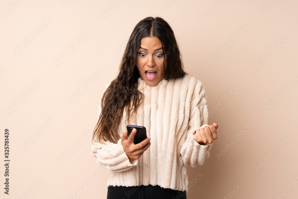 Fototapeta premium Young woman over isolated background surprised and sending a message