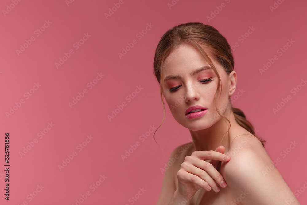Beauty portrait of smiling redhead girl. Perfect skin. Beautiful female model with long hair over pink background. Young cute woman with clear skin. Skincare and facial treatment concept. Beauty portrait of smiling redhead girl. Perfect skin. Beautiful female model with long hair over pink background. Young cute woman with clear skin. Skincare and facial treatment concept.