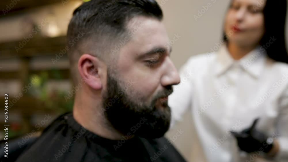 Preparing for the haircut. Bearded man comes to the barbershop Preparing for the haircut. Bearded man comes to the barbershop