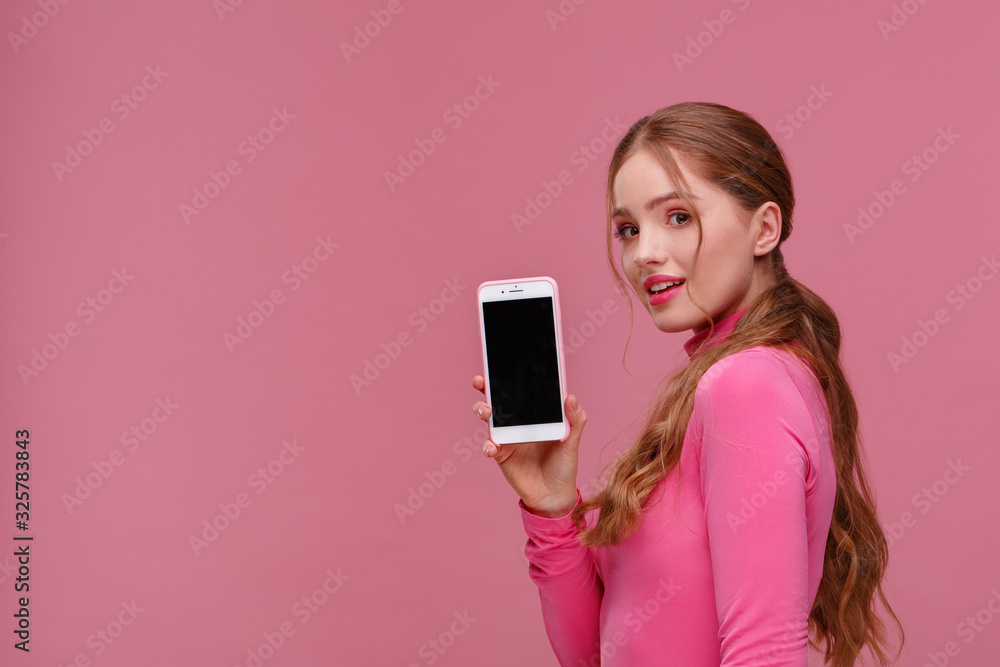 Funny redhead girl showing blank screen mobile phone on camera. Young smiling woman demonstrating smartphone display isolated over pink background. Copy space. App for your business Funny redhead girl showing blank screen mobile phone on camera. Young smiling woman demonstrating smartphone display isolated over pink background. Copy space. App for your business