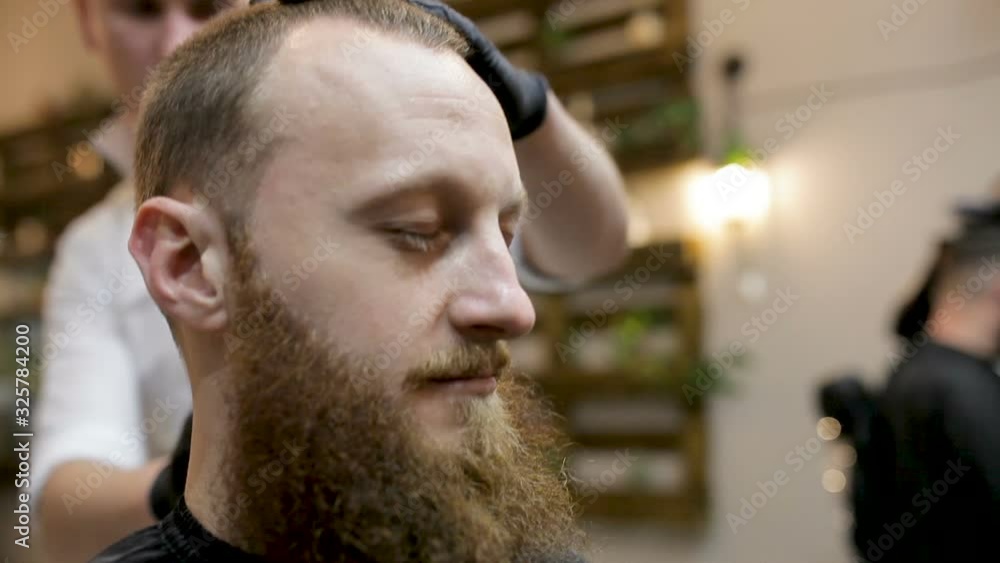 Preparing for the haircut. Bearded man comes to the barbershop Preparing for the haircut. Bearded man comes to the barbershop
