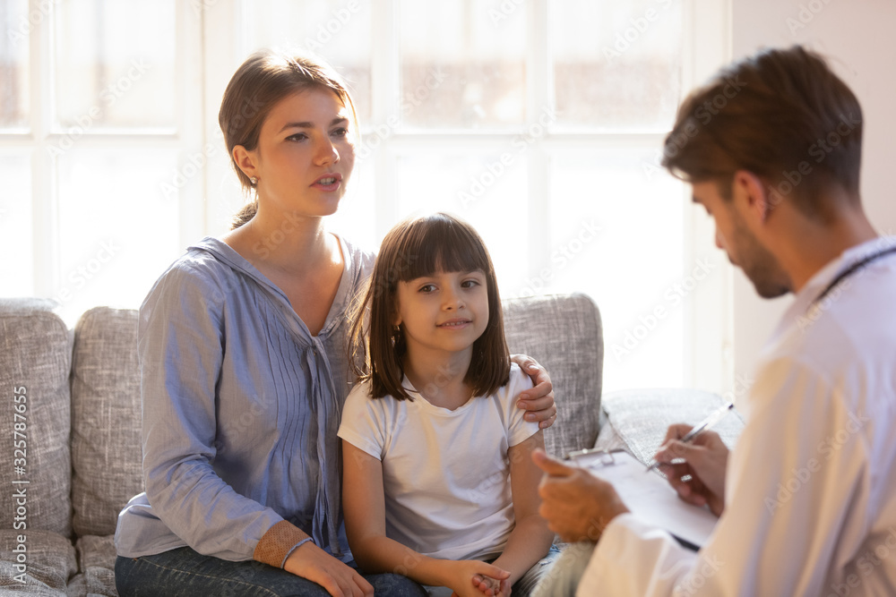 Male doctor visiting mom and daughter at home Male doctor visiting mom and daughter at home