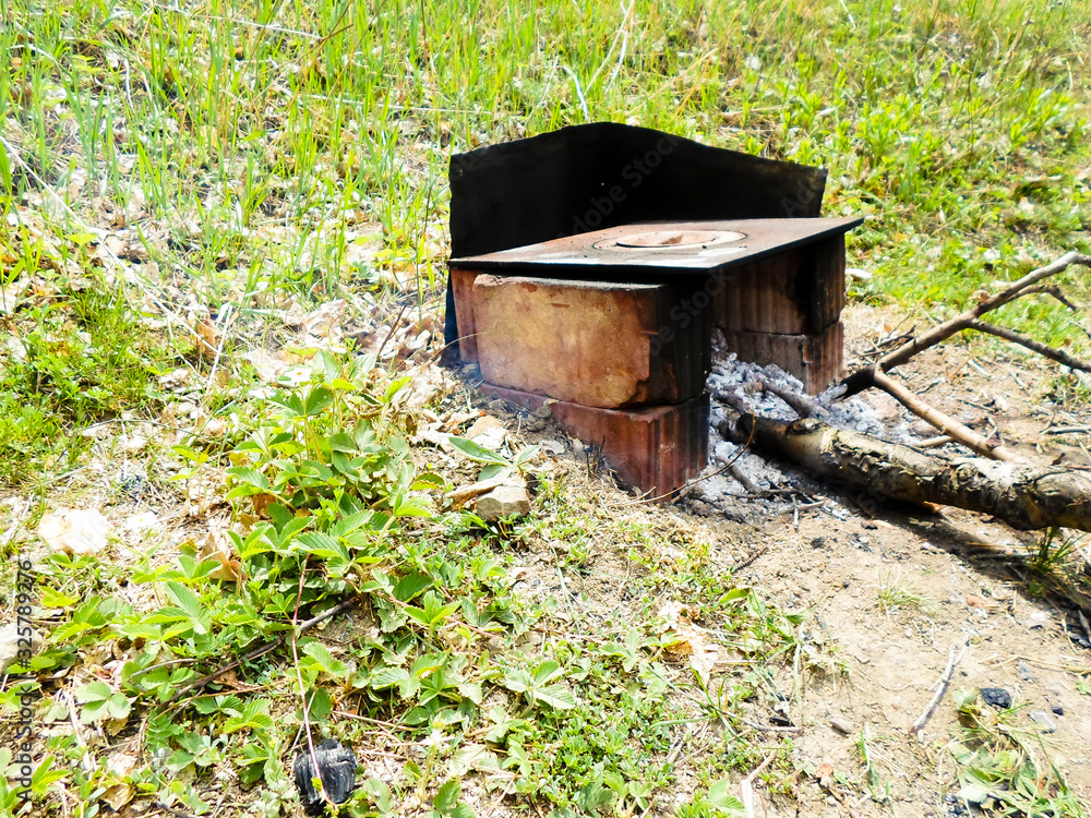 Seasonal outdoor activities, barbecue meat close-up. Drava in the stove on the coals. Nearby is a wood stove Seasonal outdoor activities, barbecue meat close-up. Drava in the stove on the coals. Nearby is a wood stove