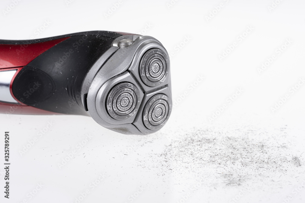 Electric shaver and gray shaved whiskers. Top view of an Electric shaver and shaved hair. Everyday hygiene and shaving Electric shaver and gray shaved whiskers. Top view of an Electric shaver and shaved hair. Everyday hygiene and shaving