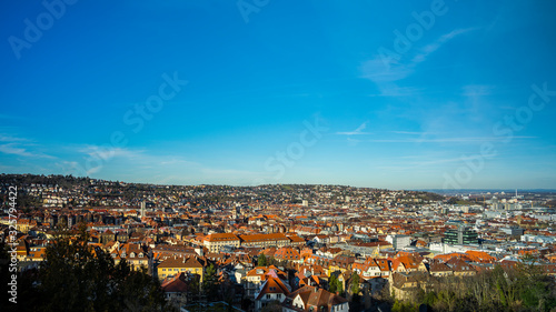 Germany, Stuttgart, Aerial view above houses, streets, churches and skyline of downtown stuttgart in basin on sunny day