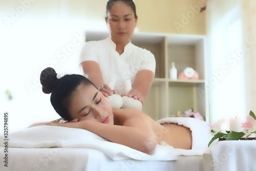 wellness, beauty and relaxation concept - young woman lying on table at spa