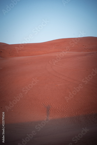 Silhouette of a woman during sunrise at Wahiba Sands desert, Oman