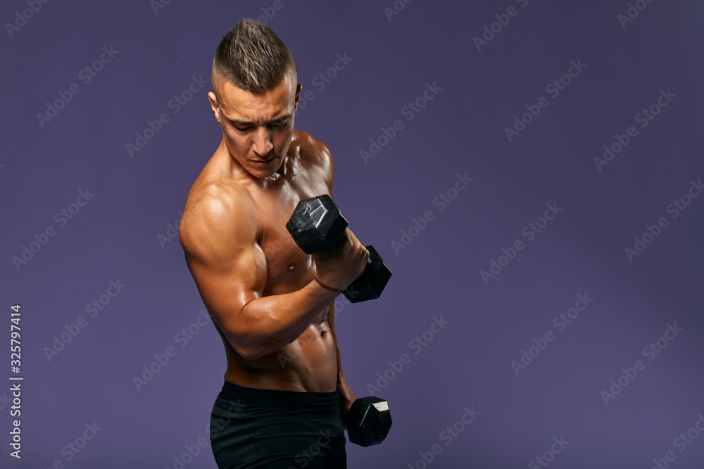 muscular ambitious motivated athletic man with weight, isolated on blue, close up portrait, copy space. health and body care,free time, spare time, hobby, interest