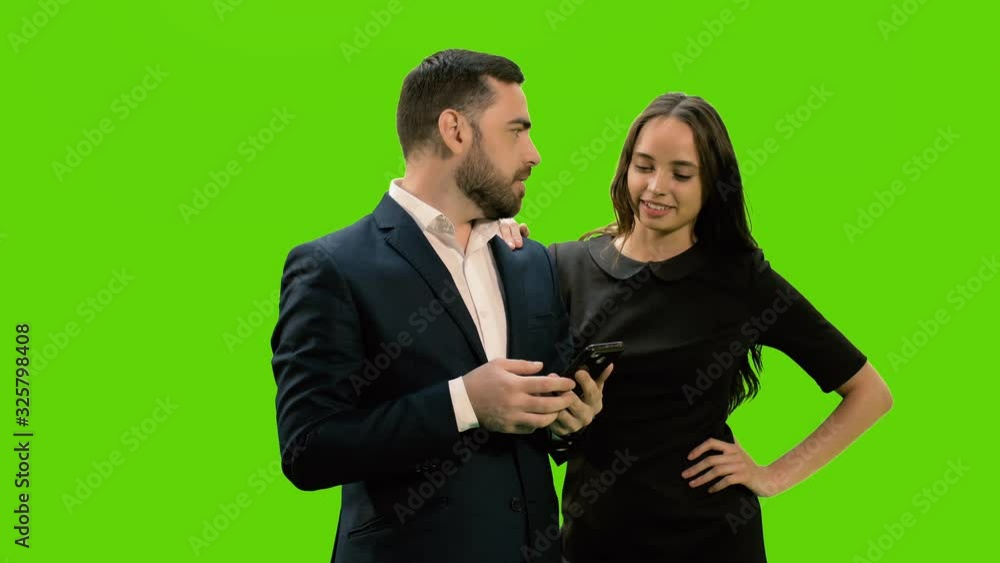 Two business partners using smartphone against green screen background, Chroma key, 4k pre-keyed footage Two business partners using smartphone against green screen background, Chroma key, 4k pre-keyed footage