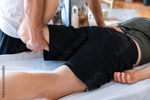Photography Unrecognizable man massaging legs of a young man lying on the massage table