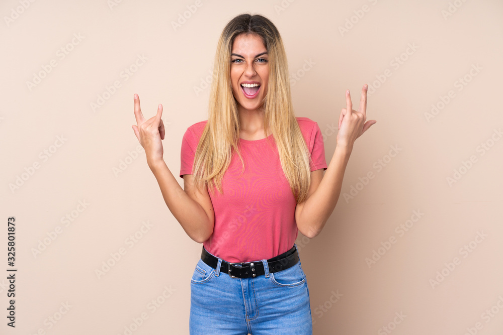 Young Uruguayan woman over isolated background making rock gesture Young Uruguayan woman over isolated background making rock gesture
