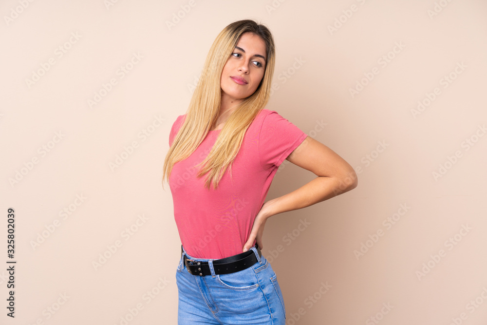 Young Uruguayan woman over isolated background suffering from backache for having made an effort Young Uruguayan woman over isolated background suffering from backache for having made an effort