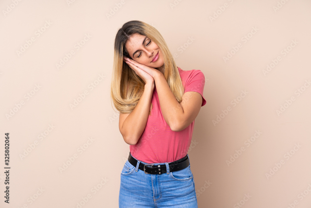 Young Uruguayan woman over isolated background making sleep gesture in dorable expression Young Uruguayan woman over isolated background making sleep gesture in dorable expression